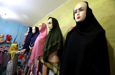 Penjual merapikan hijab di toko busana muslim di kawasan Pondok Melati, Kota Bekasi, Jawa Barat, Jumat (2/4/2021).