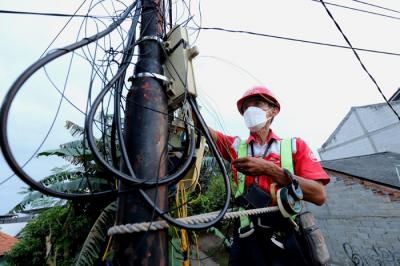 Teknisi sedang melakukan perawatan jaringan IndiHome di kawasan Pedurenan, Kota Bekasi, Jawa Barat, Jumat (2/4/2021).