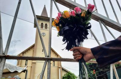 Peserta aksi yang tergabung dalam Forum Rakyat Bersatu memegang bunga saat aksi solidaritas di depan Gereja Katedral, Makassar, Sulsel, Minggu (4/4/2021).