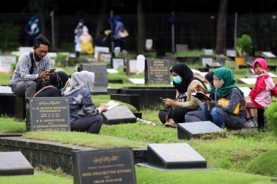 Warga melakukan ziarah kubur di TPU Tanah Kusir, Jakarta, Senin (5/4/2021).