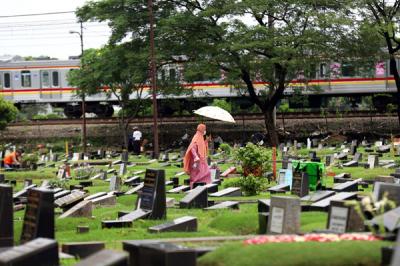 Warga melakukan ziarah kubur di TPU Tanah Kusir, Jakarta, Senin (5/4/2021).