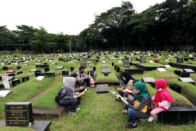 Warga melakukan ziarah kubur di TPU Tanah Kusir, Jakarta, Senin (5/4/2021).