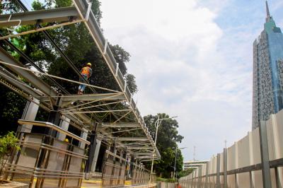 Pekerja menyelesaikan pembuatan halte di Stasiun Palmerah, Jakarta Pusat, Senin (5/4/2021).