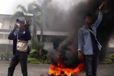 Mahasiswa meluapkan emosi dengan membakar ban bekas saat melakukan aksi demonstrasi didepan kampus Universitas DR. Soetomo (Unitomo) Surabaya, Kamis (8/4/2021).