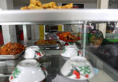 Penjual melayani pembeli di Warteg Kharisma di kawasan Jakarta Timur, Kamis (8/4/2021).