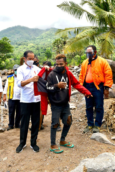 Presiden Jokowi memberikan jaket pribadinya kepada Fransiskus Ade Uran Atawalo, saat mengunjungi Desa Amakaka Kecamatan Ile Ape, Lembata, NTT, Jumat (9/4/2021).