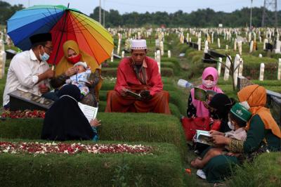 Peziarah berdoa dipisara makam kerabatnya yang dimakamkan di makam khusus Covid-19, Keputih Surabaya, Jawa Timur, Jumat (9/4/2021).