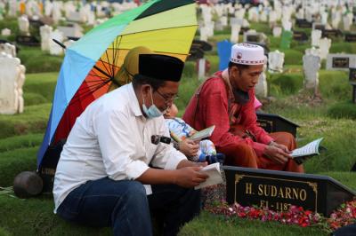 Peziarah berdoa dipisara makam kerabatnya yang dimakamkan di makam khusus Covid-19, Keputih Surabaya, Jawa Timur, Jumat (9/4/2021).
