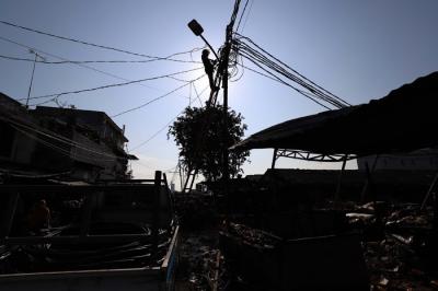 Petugas PLN melakukan perbaikan jarinngan listrik di lokasi pasca kebakaran di Pasar Kambing, Kebon Melati, Tanah Abang, Jakarta, Jumat (9/4/2021).