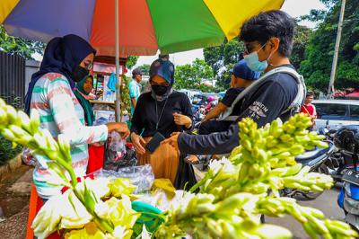 Pedagang bunga tabur melayani warga yang berbelanja bunga dan air mawar di pintu masuk TPU Karet Bivak, Jakarta, Minggu (11/4/2021).