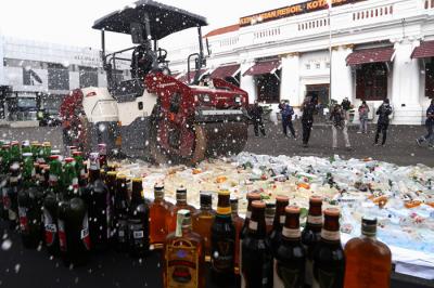 Polisi memusnahkan ribuan barang bukti minuman keras pada hari pertama puasa Ramadan, di halaman Mapolrestabes Surabaya, Jawa Timur, Selasa (13/4/2021).