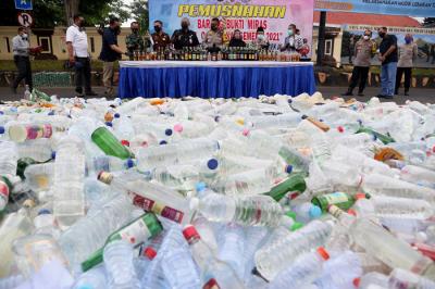 Polisi memusnahkan ribuan barang bukti minuman keras pada hari pertama puasa Ramadan, di halaman Mapolrestabes Surabaya, Jawa Timur, Selasa (13/4/2021).