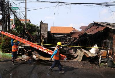 Petugas PLN memperbaiki jaringan listrik yang terputus pasca kebakaran bengkel mebel di Jalan Semolowaru, Surabaya, Kamis (15/4/2021).