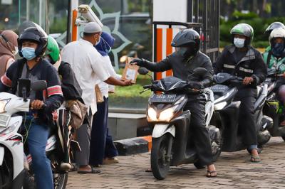 Pengurus masjid membagikan takjil gratis di halaman Masjid Al-Azhar, Jakarta, Kamis (15/4/2021).