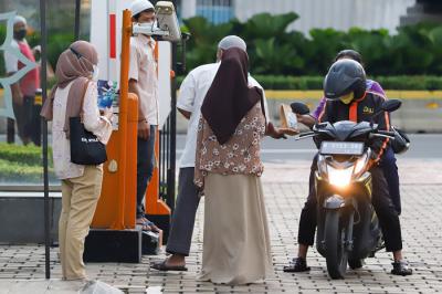 Pengurus masjid membagikan takjil gratis di halaman Masjid Al-Azhar, Jakarta, Kamis (15/4/2021).