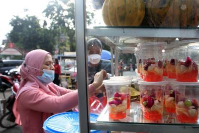 Pedagang melayani pembeli makanan untuk berbuka puasa di Pasar Takjil Benhil, Jakarta, Jumat (16/4/21).