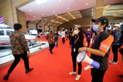 Satgas Covid 19 berpatroli mengelilingi booth pameran IIMS Hybrid 2021 mengingatkan pengunjung untuk selalu menerapkan prokes di Jakarta, Kamis (15/4/2021).