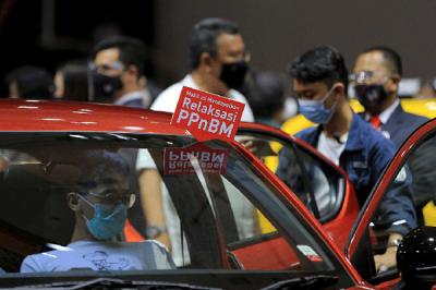 Pengunjung mengamati mobil yang dipamerkan pada ajang Indonesia International Motor Show (IIMS) Hybrid 2021 di JiExpo Kemayoran, Jakarta, Minggu (18/4/2021).