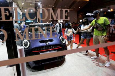 Pengunjung mengamati mobil yang dipamerkan pada ajang Indonesia International Motor Show (IIMS) Hybrid 2021 di JiExpo Kemayoran, Jakarta, Minggu (18/4/2021).