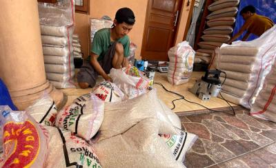 Pekerja mengemas beras di salah satu gudang di kawasan Jakarta Timur, Senin (19/4/2021).