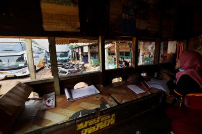 Penjual tiket Bus AKAP menunggu calon pemudik didalam loket penjualan tiket di Pool Bus di Pasar Lembang, Ciledug, Tangerang, Banten, Selasa (20/4/2021).