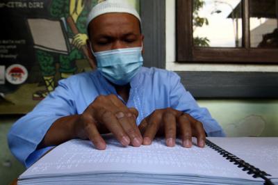 Sejumlah penyandang disabilitas dari Komunitas Mata Hati (KMH) Surabaya membaca Alquran Braile di markas KMH Surabaya, Jawa Timur, Selasa (20/4/2021).