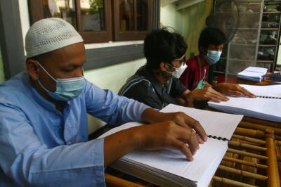 Sejumlah penyandang disabilitas dari Komunitas Mata Hati (KMH) Surabaya membaca Alquran Braile di markas KMH Surabaya, Jawa Timur, Selasa (20/4/2021).