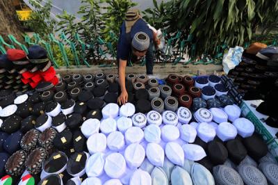 Penjual merapikan peci di kawasan Cillitan, Jakarta Timur, Selasa (20/4/2021).