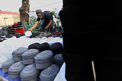 Penjual merapikan peci di kawasan Cillitan, Jakarta Timur, Selasa (20/4/2021).