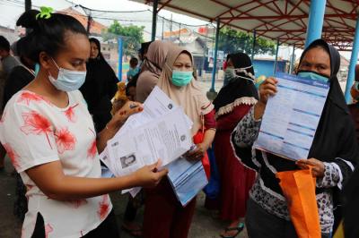 Warga antre untuk mencairkan dana bantuan UMKM di Dermaga Pelabuhan Pulau Panggang, Kepulauan Seribu Utara, Provinsi DKI Jakarta, Selasa (20/4/2021).