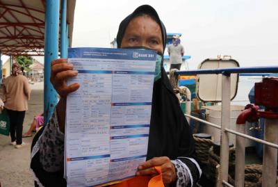 Warga antre untuk mencairkan dana bantuan UMKM di Dermaga Pelabuhan Pulau Panggang, Kepulauan Seribu Utara, Provinsi DKI Jakarta, Selasa (20/4/2021).