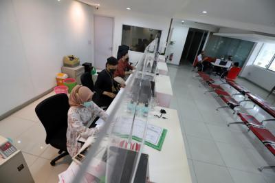 Petugas merapikan uang rupiah di salah satu bank di Jakarta, Kamis (22/4/2021).