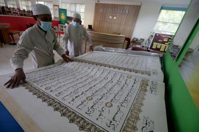 Petugas merawat Alquran raksasa di Perpustakaan Jakarta Islamic Centre (JIC), Jakarta Utara, Jumat (23/4/2021).
