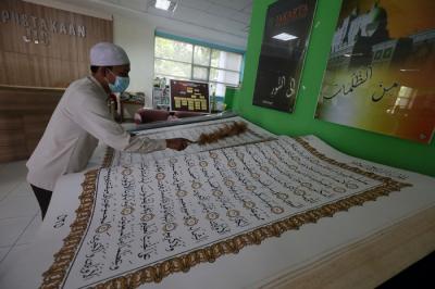 Petugas merawat Alquran raksasa di Perpustakaan Jakarta Islamic Centre (JIC), Jakarta Utara, Jumat (23/4/2021).