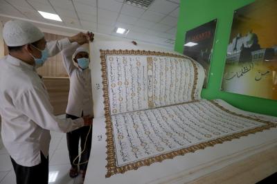 Petugas merawat Alquran raksasa di Perpustakaan Jakarta Islamic Centre (JIC), Jakarta Utara, Jumat (23/4/2021).