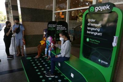 Pelanggan menunggu jemputan di titik jemput dan antar Gojek instan di Royal Plaza Surabaya, Jawa Timur, Kamis (22/4/2021).