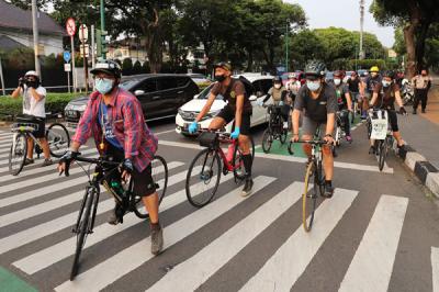 Polisi menghalau Peserta aksi bersepeda saat unjuk rasa bertajuk Gowes for Democracy #SaveMyanmar di Jakarta, Sabtu, (24/4/2021).