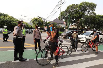 Polisi menghalau Peserta aksi bersepeda saat unjuk rasa bertajuk Gowes for Democracy #SaveMyanmar di Jakarta, Sabtu, (24/4/2021).