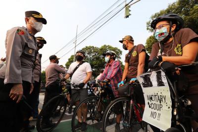 Polisi menghalau Peserta aksi bersepeda saat unjuk rasa bertajuk Gowes for Democracy #SaveMyanmar di Jakarta, Sabtu, (24/4/2021).