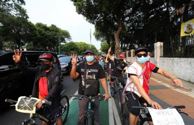 Polisi menghalau Peserta aksi bersepeda saat unjuk rasa bertajuk Gowes for Democracy #SaveMyanmar di Jakarta, Sabtu, (24/4/2021).