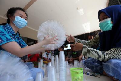 Sejumlah anak belajar membuat lampu gantung berbahan gelas air mineral bekas di Kampung Herbal, Surabaya, Jawa Timur, Sabtu (24/4/2021).