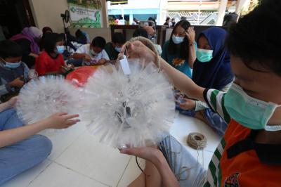 Sejumlah anak belajar membuat lampu gantung berbahan gelas air mineral bekas di Kampung Herbal, Surabaya, Jawa Timur, Sabtu (24/4/2021).