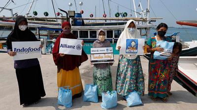 Sejumlah wartawan dari komunitas Jurnalis Peduli menyalurkan bantuan paket sembako kepada warga pesisir di Pulau Panjang, Banten, Sabtu (24/4/2021).