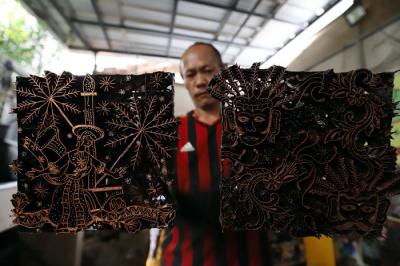 Pekerja menyelesaikan pewarnaan batik di lokasi pembuatan batik terogong khas betawi di Jakarta, Selasa (27/4/2021).