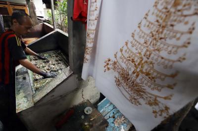 Pekerja menyelesaikan pewarnaan batik di lokasi pembuatan batik terogong khas betawi di Jakarta, Selasa (27/4/2021).