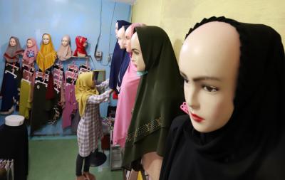 Penjual merapikan hijab di toko busana muslim di kawasan Pondok Melati, Kota Bekasi, Jawa Barat, Kamis (29/4/2021).