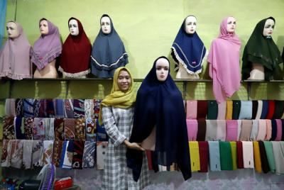 Penjual merapikan hijab di toko busana muslim di kawasan Pondok Melati, Kota Bekasi, Jawa Barat, Kamis (29/4/2021).