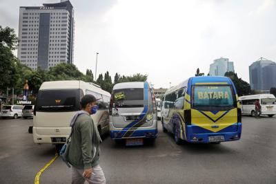 Petugas kepolisian memeriksa barang bukti kendaraan travel gelap di Lapangan Presisi Dit Lantas PMJ, Jakarta, Kamis (29/4/2021).