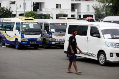 Petugas kepolisian memeriksa barang bukti kendaraan travel gelap di Lapangan Presisi Dit Lantas PMJ, Jakarta, Kamis (29/4/2021).