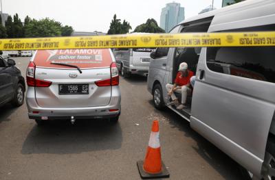 Petugas kepolisian memeriksa barang bukti kendaraan travel gelap di Lapangan Presisi Dit Lantas PMJ, Jakarta, Kamis (29/4/2021).